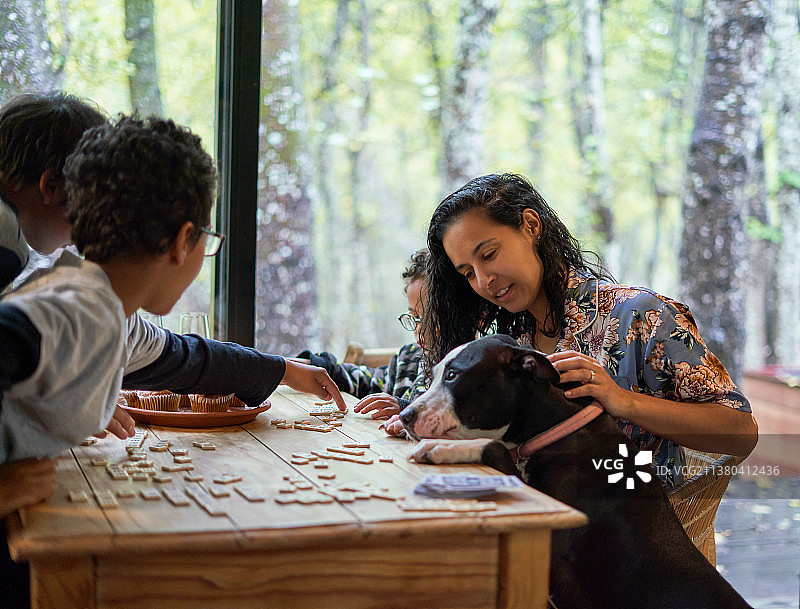 一家人和狗在餐桌旁玩拼字游戏图片素材