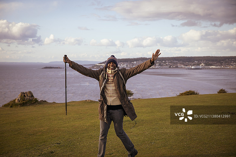 在海边悬崖上徒步的无忧无虑的男人图片素材