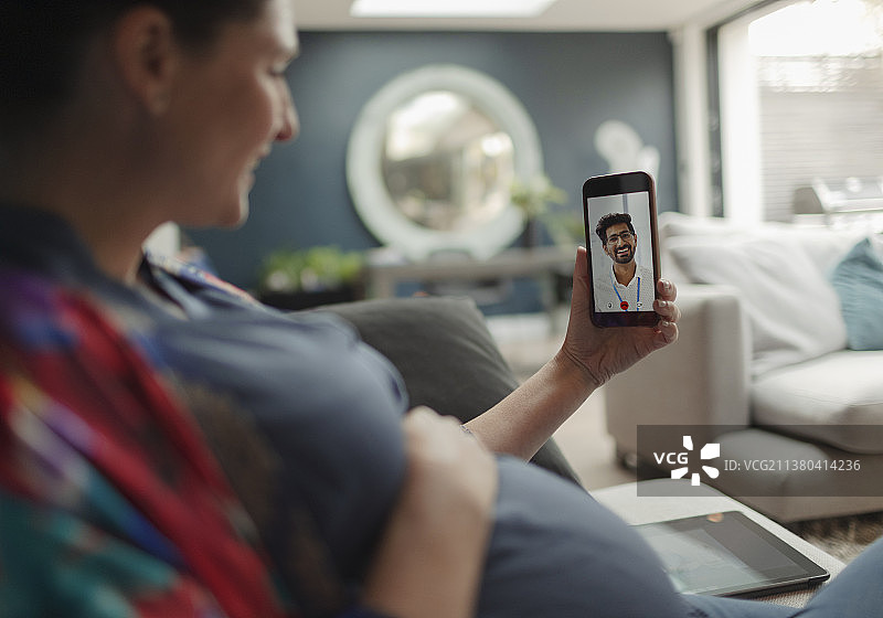 孕妇在智能手机屏幕上与医生进行视频聊天图片素材