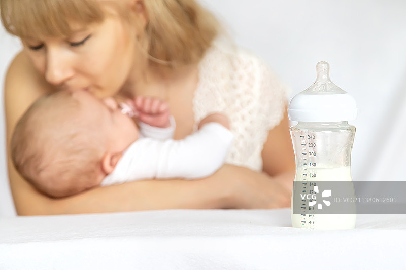 母亲用奶瓶喂宝宝，局部聚焦图片素材