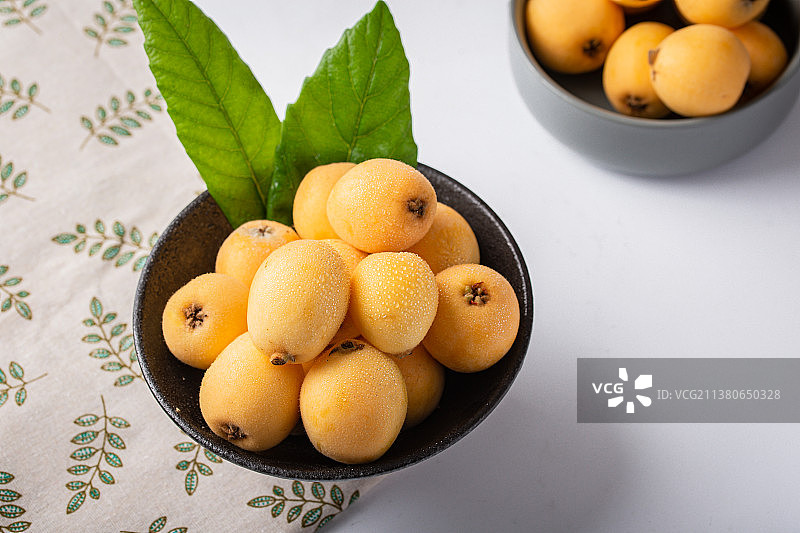 棚拍静物白底上的新鲜枇杷与枇杷叶图片素材