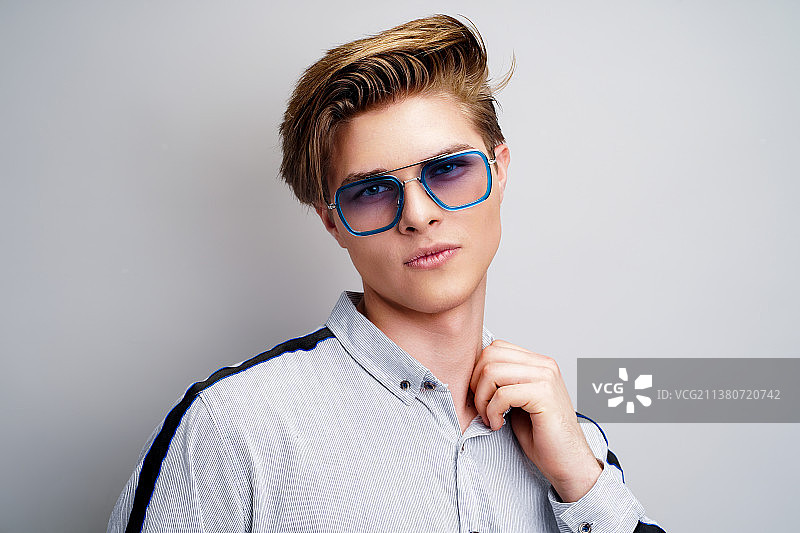 戴时尚眼镜的年轻潮男看着镜头图片素材