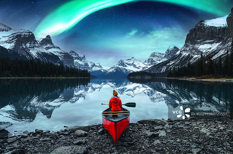 女游客在独木舟上欣赏加拿大不列颠哥伦比亚省精灵岛的北极光图片素材