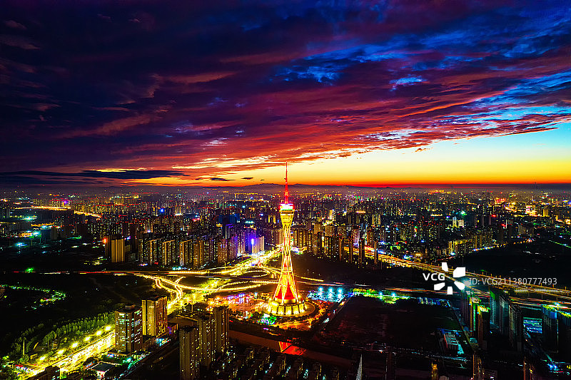 中国河南郑州经济开发区中原福塔夏季日落时分高视角航拍夜景都市风光图片素材