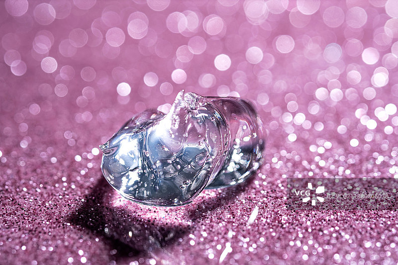 粉色闪亮背景上的透明质酸凝胶图片素材