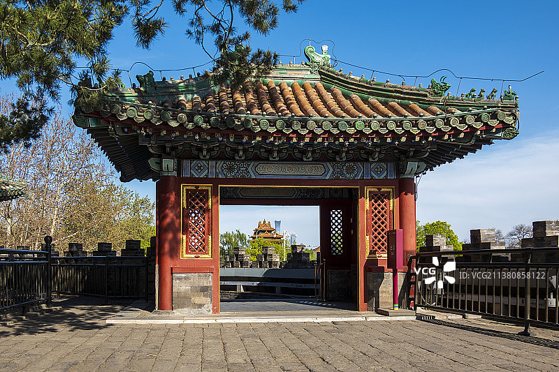 春天北海团城昭景门透过罩门远眺故宫角楼和北京中信大厦图片素材