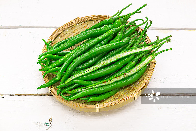 白色木板上的一竹筐青线椒图片素材