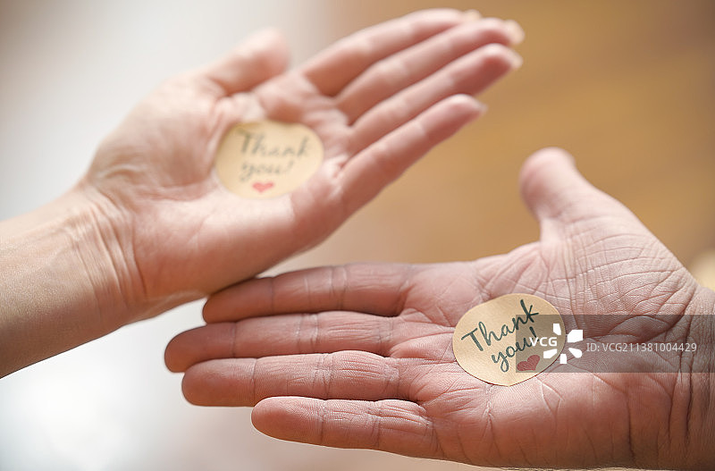 男女手持“谢谢”贴纸图片素材