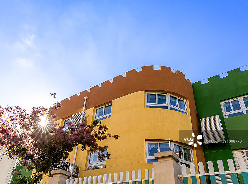 夕阳下长城箭垛造型的彩色幼儿园建筑图片素材