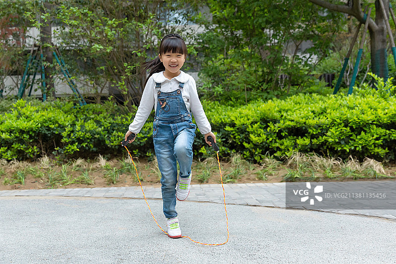 在户外跳绳的亚洲小女孩图片素材