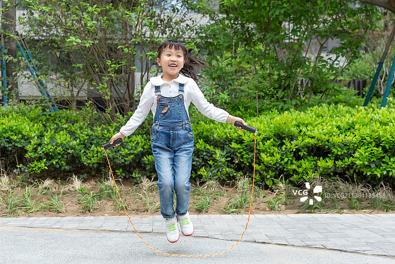 在户外跳绳的亚洲小女孩图片素材