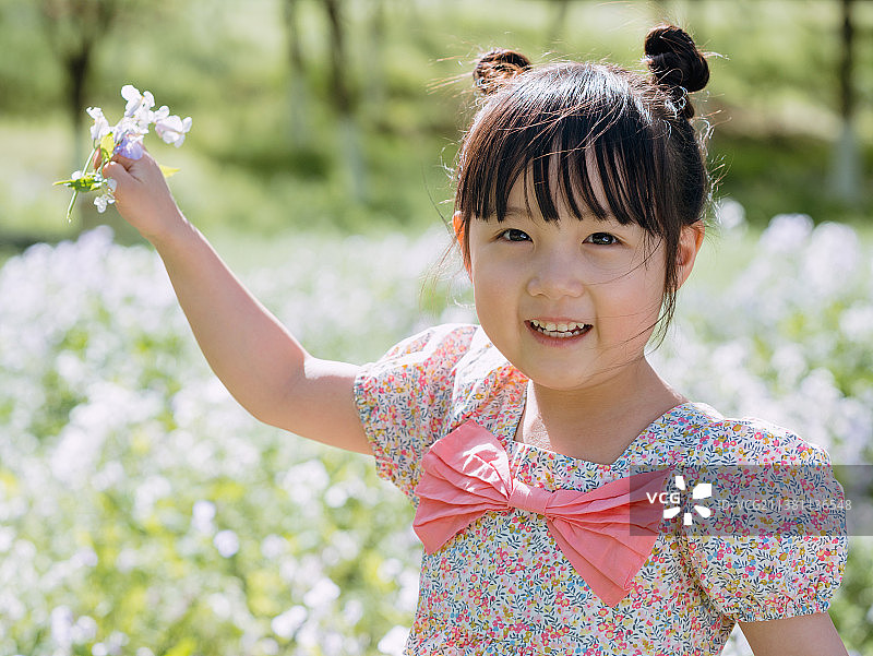 小女孩在公园花田玩耍图片素材