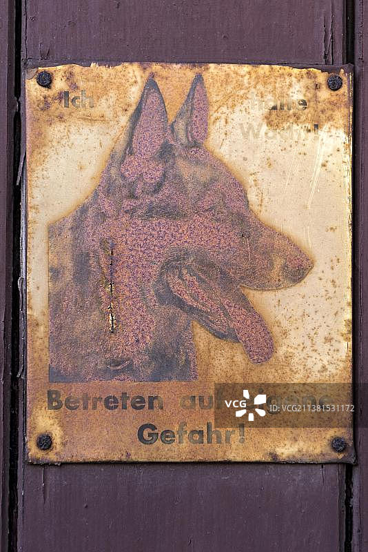 生锈的牧羊犬警告牌：擅自进入，后果自负，位于德国黑森州福格尔斯贝格山施利茨老城区图片素材