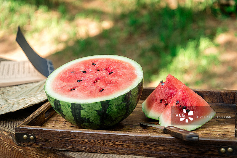 夏季午后户外木桌上切开的冰镇西瓜图片素材