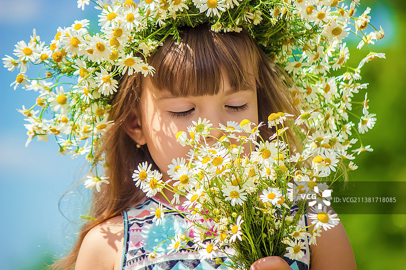 以洋甘菊为背景，带有选择性聚焦效果的女孩图片素材