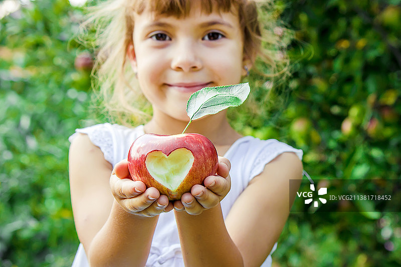 拿着苹果的儿童，花园背景图片素材