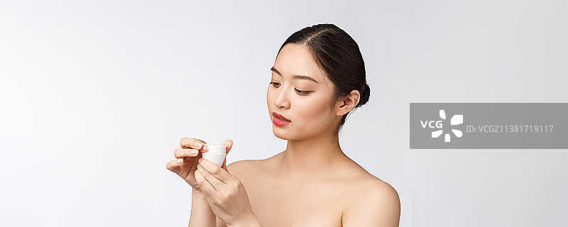 手持化妆品的白色背景美丽年轻女人图片素材