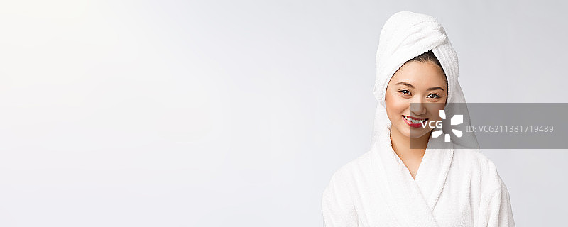 穿着浴袍的快乐亚洲年轻女士肖像图片素材