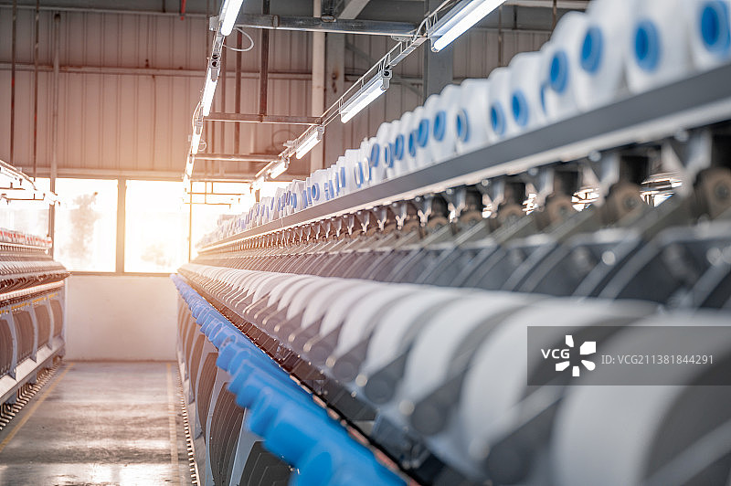 纺织工厂纺纱车间整齐排列的纺纱线内景图片素材