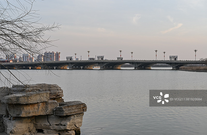 中国开封汴西湖大桥湖面游船与建筑楼群图片素材