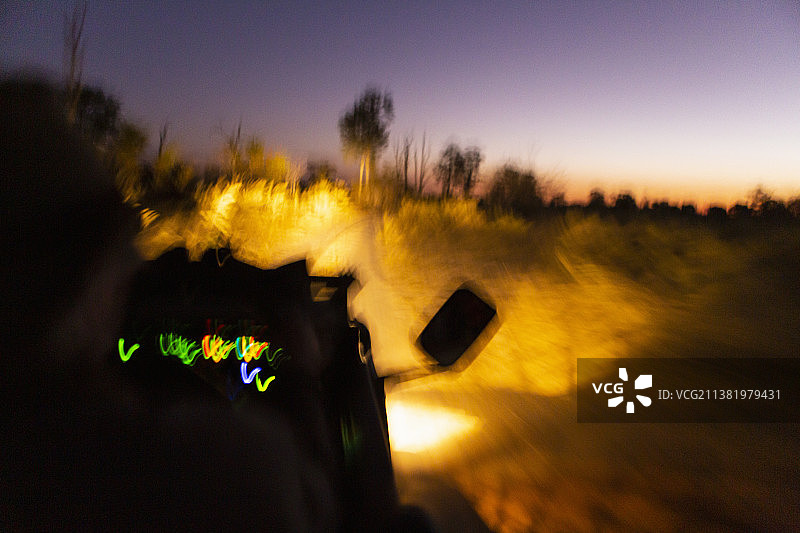 博茨瓦纳奥卡万戈三角洲，日落后在道路上行驶的车辆图片素材