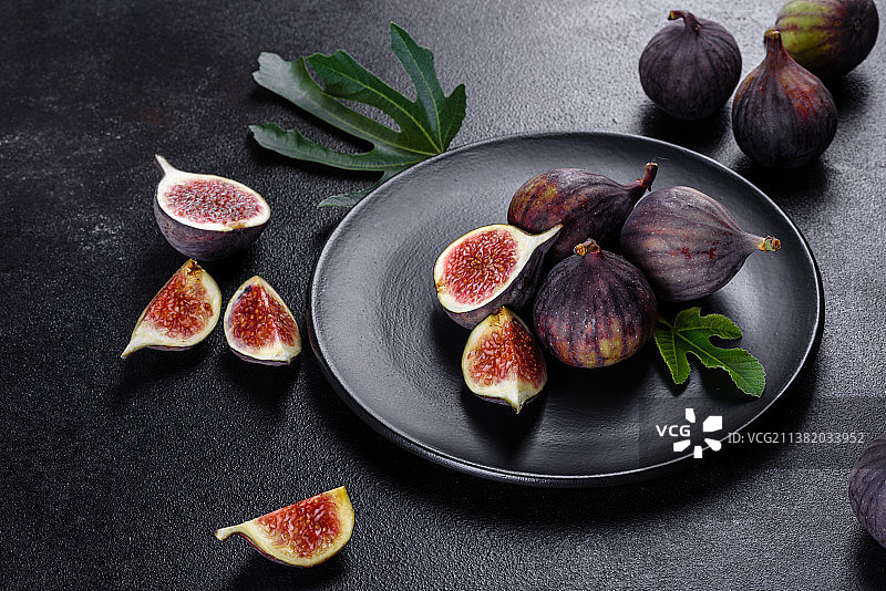 深色混凝土背景上的新鲜成熟无花果，无花果采摘图片素材