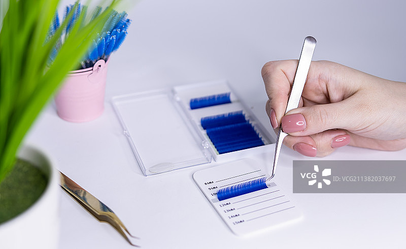 睫毛嫁接材料，女孩手持镊子和睫毛图片素材