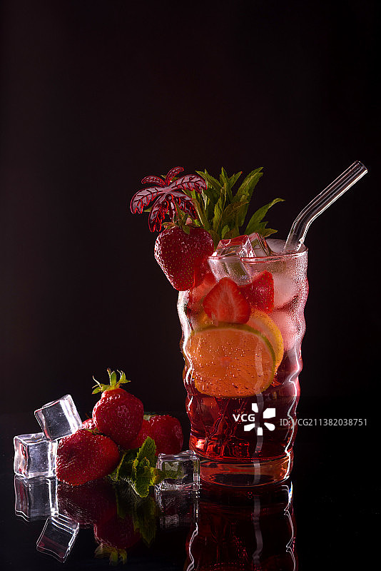 黑色背景下玻璃杯中的草莓特写图片素材