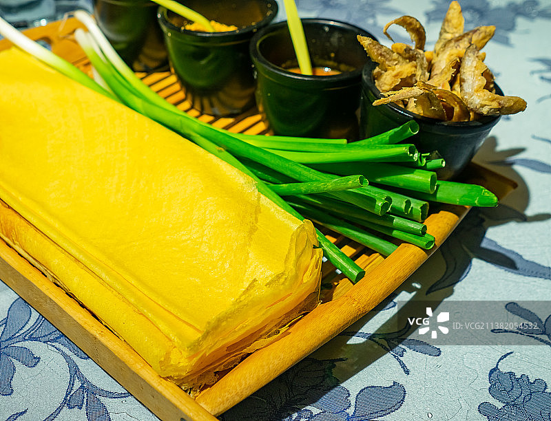 中国餐饮行业饮食产业，传统经典中国食品，美食拍摄主题，一盘子山东煎饼卷大葱美食特写，室内无人图像图片素材