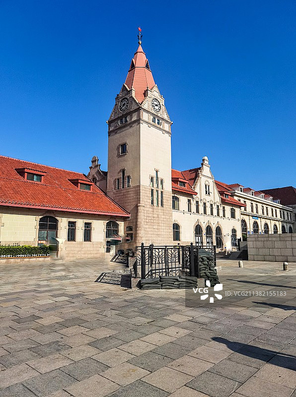 蓝色天空映衬下的中国山东青岛火车站钟表楼历史建筑景观图片素材