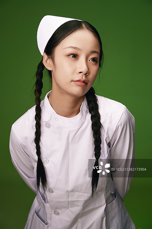 绿色背景里身穿白色护士服的年轻护士形象图片素材