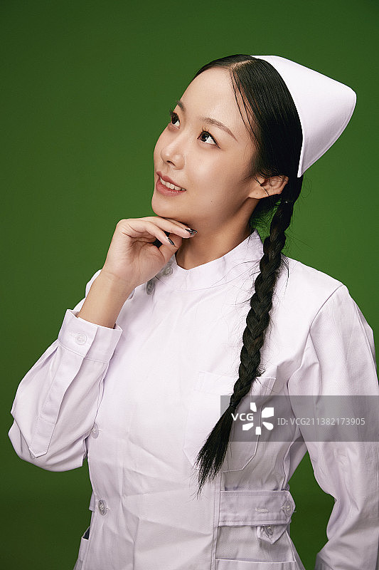 绿色背景里身穿白色护士服的年轻护士形象图片素材