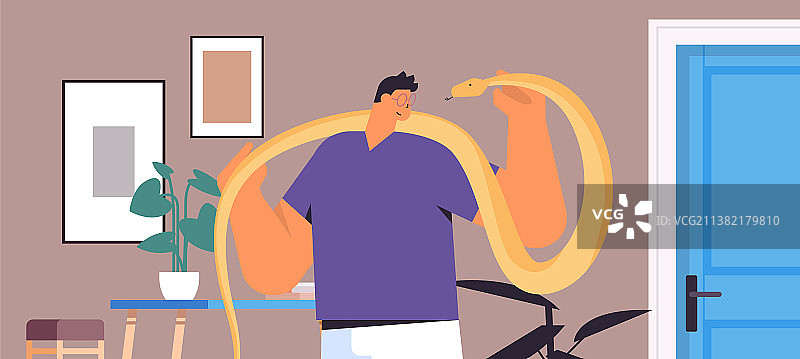 男子手持黄色蟒蛇图片素材