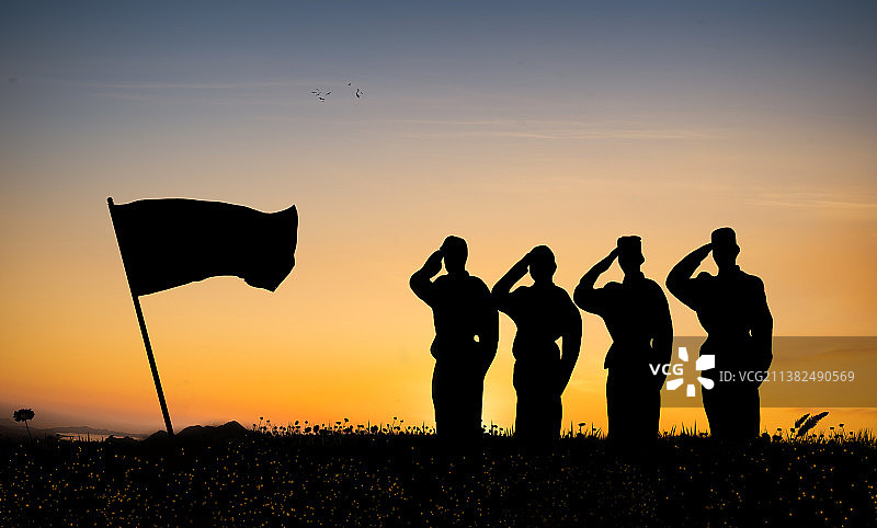 夕阳下军队战士对着旗帜行军礼图片素材