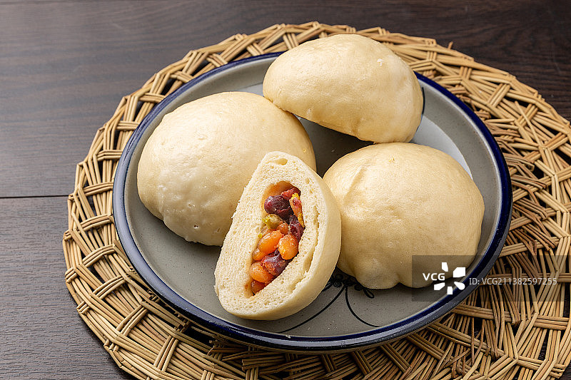 装在盘子里的糖纳多彩豆馅包图片素材