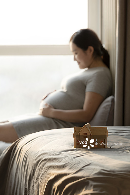 幸福的孕妇妈妈和房屋模型图片素材