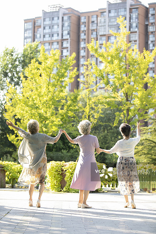 快乐的老年闺蜜在公园跳舞图片素材
