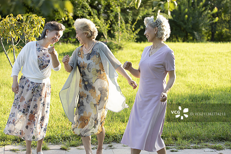 快乐的老年闺蜜在公园跳舞图片素材