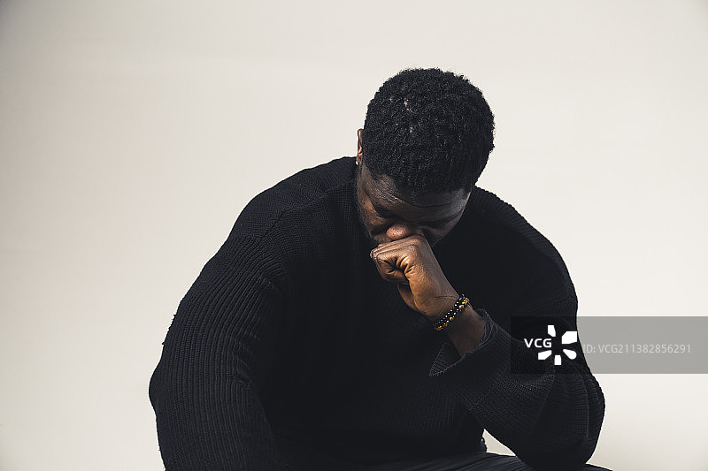 被打倒的有色人种男子，脸上带着拳头向下看图片素材