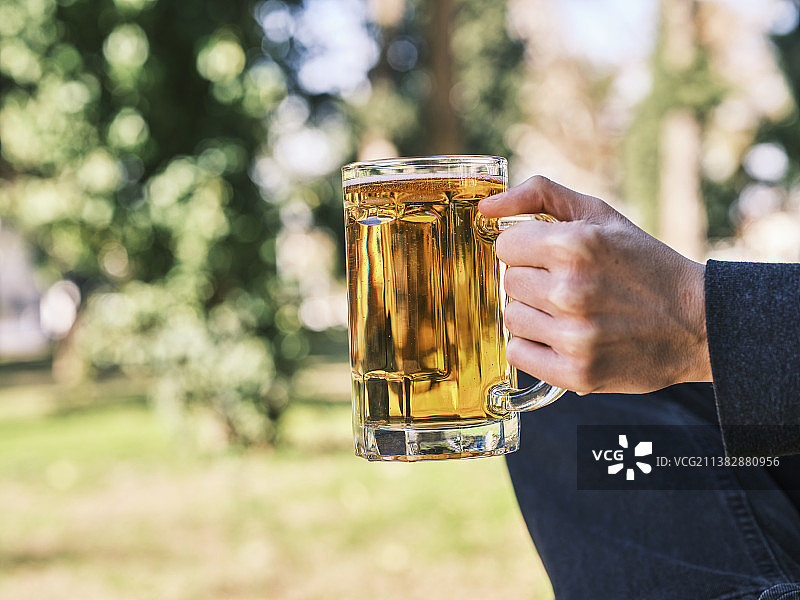 手持冰啤酒杯的男人（特写）图片素材
