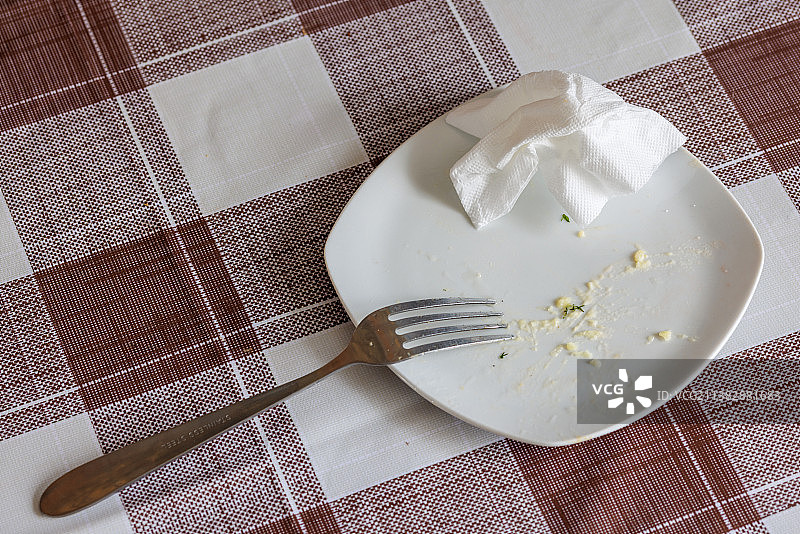 吃剩食物的空白色盘子和揉皱的餐巾图片素材