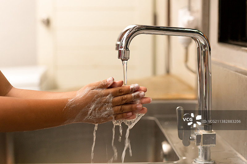 儿童在水龙头下用洗手液洗手图片素材