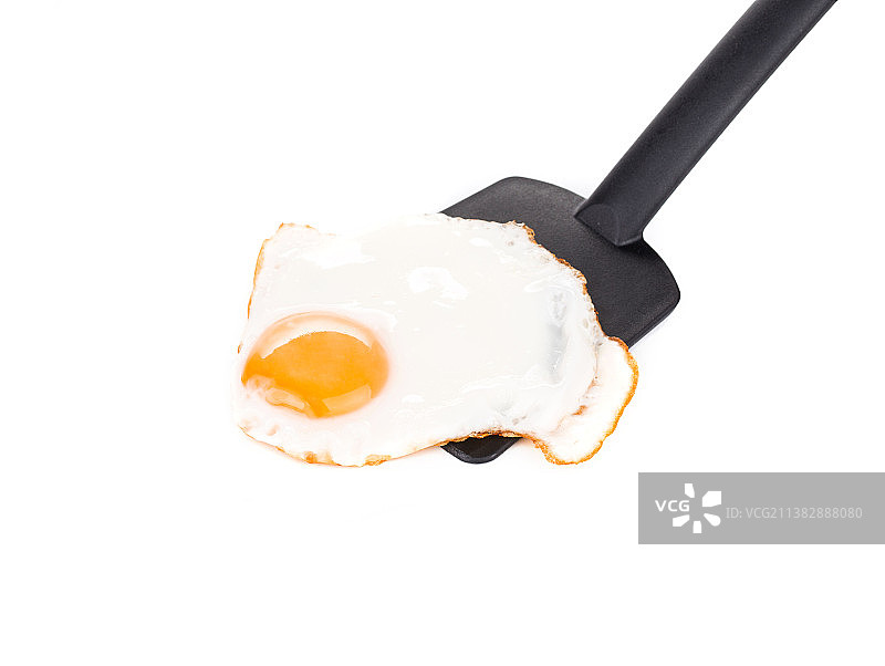 白色背景下用铲子煎鸡蛋特写，摩尔多瓦图片素材