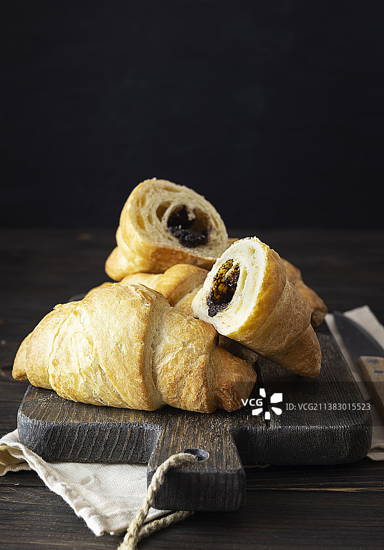 木板上的巧克力馅香脆牛角包图片素材