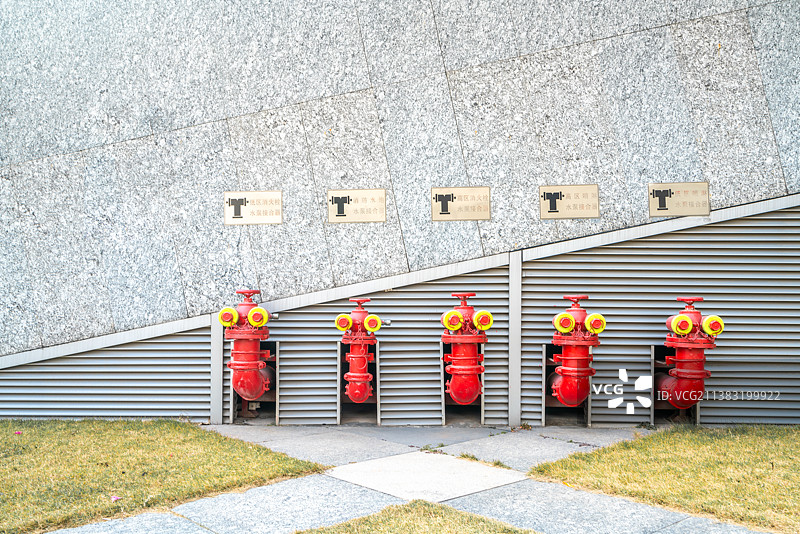 大型公共场所排成一排的五个防火消防车水泵接合器消防栓图片素材