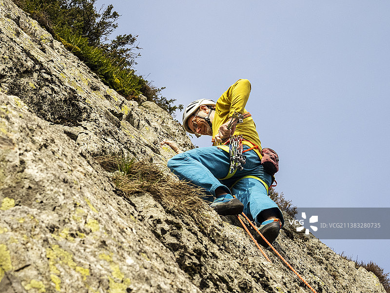 中年登山者在英国湖区康尼斯顿附近的蒂尔伯斯韦特悬崖上开辟新路线图片素材