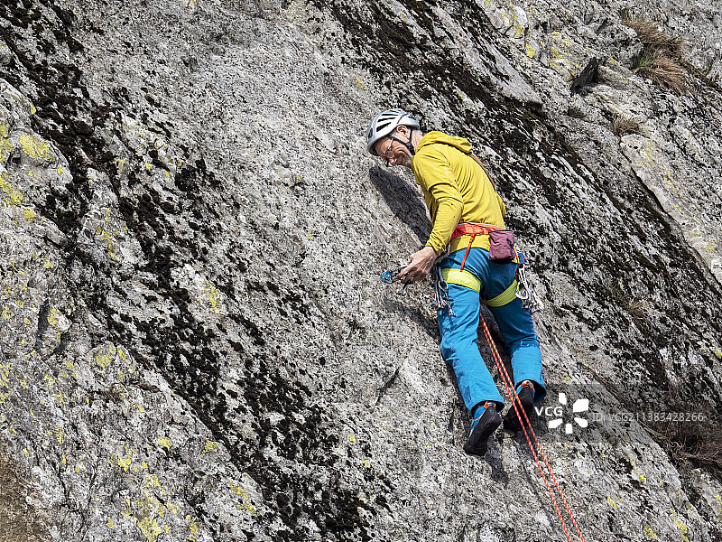 中年登山者在英国康尼斯顿附近的蒂尔伯斯韦特悬崖上开辟新路线图片素材