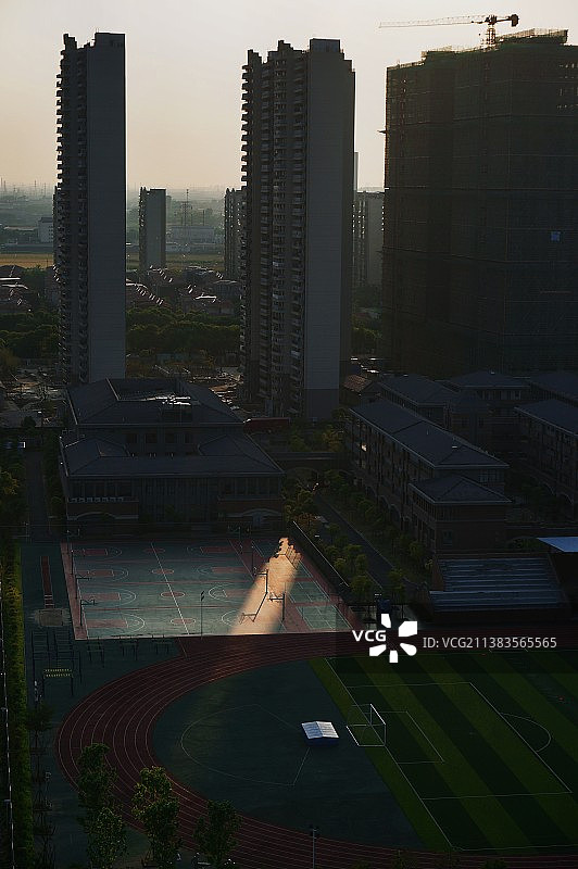被高楼包围的学校操场里的一束光图片素材