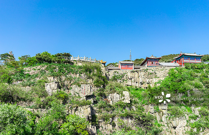 中国非都市风光拍摄主题，山东省泰安市国内著名景点泰山风景区，低视角仰拍玉皇顶连绵不绝的山谷悬崖和蓝天图片素材