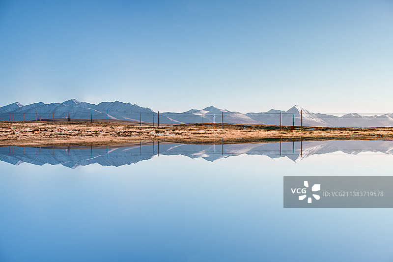 西藏蓝色天空下的雪山倒映在湖面上图片素材